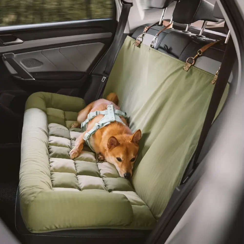Deluxe Dog Car Seat Bed in green with padded cushion and backrest, designed for large dogs, installed in car back seat with safety straps and anti-slip bottom, providing comfort and security for pets during travel.