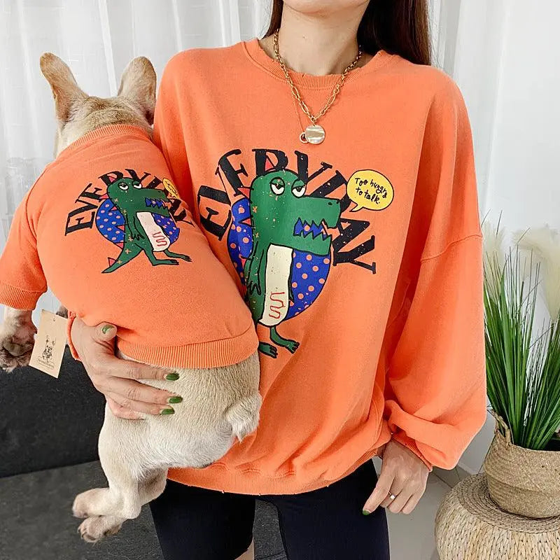 Matching orange panda love pet and parent outfits with cartoon dinosaur design