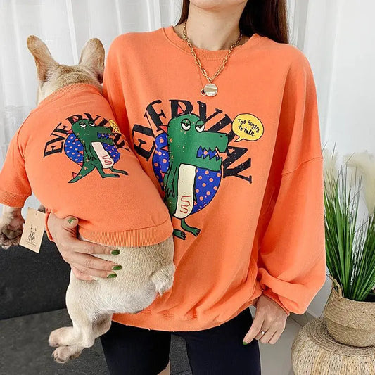 Matching orange panda love pet and parent outfits with cartoon dinosaur design
