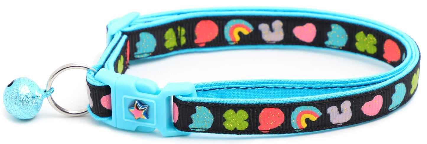 Cereal Marshmallows Breakaway Cat Collar with blue buckle, bell, and colorful heart, rainbow, and clover pattern on reinforced cotton strap