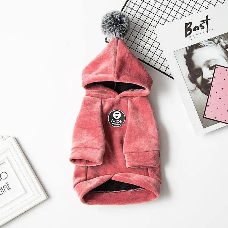 Cozy pink pet hoodie with pom-pom hood and Aape logo, soft fabric pet sweater for warmth and style