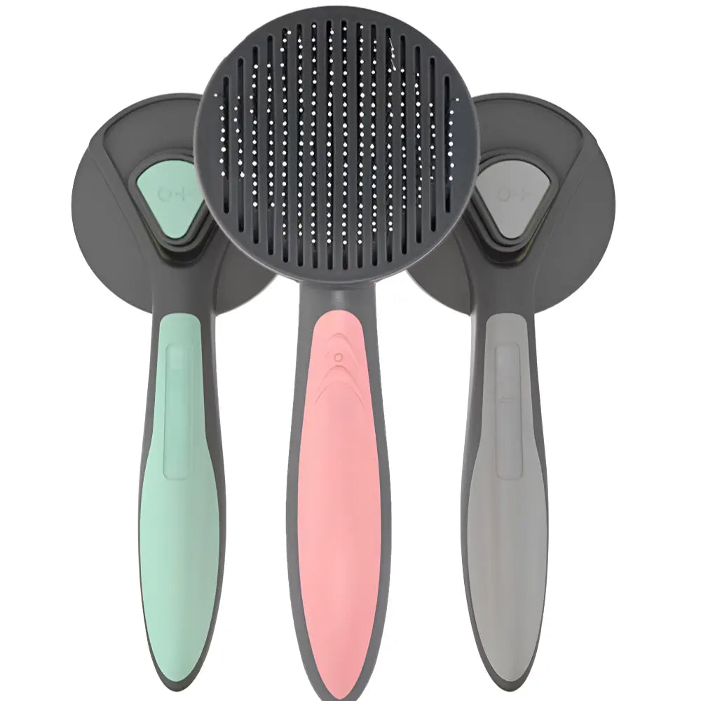 Three self-cleaning deshedding combs with ergonomic handles in mint green, pink, and gray colors, designed for removing loose fur and undercoat from pets.