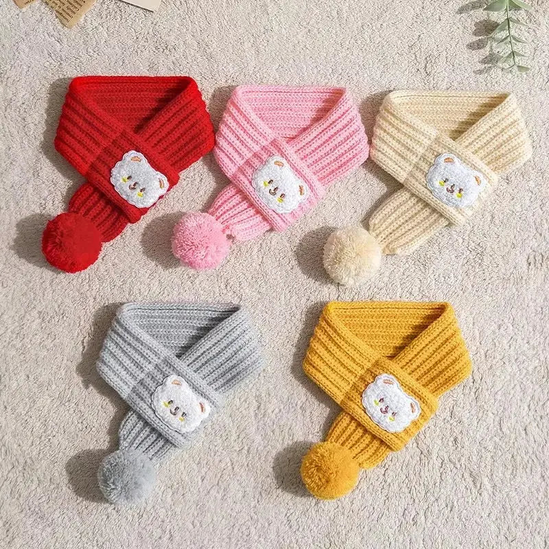 Colorful SnugTail Knit Scarves for pets with pom-poms and bear face design in red, pink, cream, gray, and yellow.